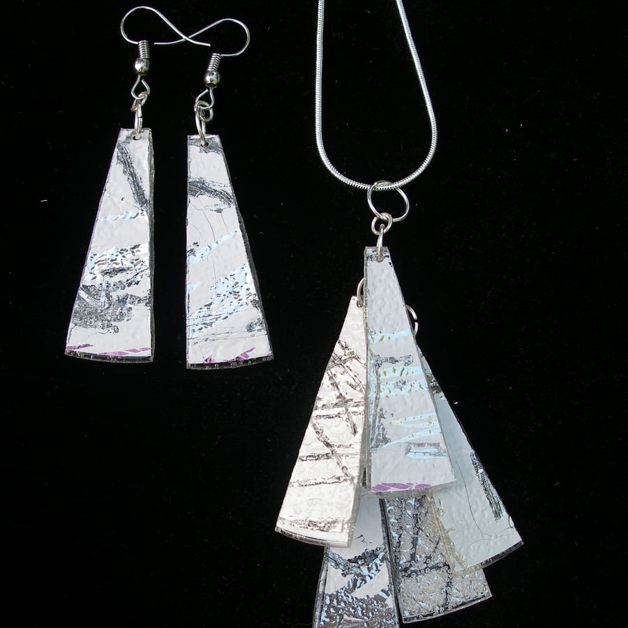 Matched set silver and white earrings and a pendant.