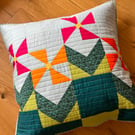 Pink & orange geometric flowers on a quilted floor cushion