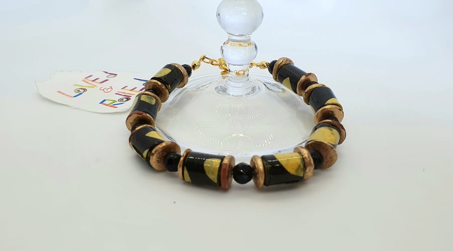Black and yellow paper beaded bracelet with distressed bronze red spacers