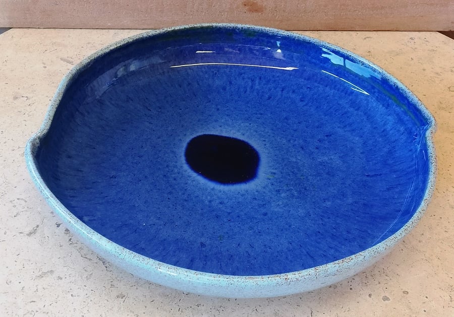 Glossy blue ceramic plate with melted bead center
