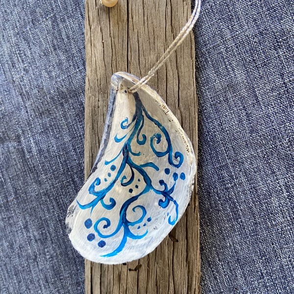 Hand painted mussel shell from an Argyll beach. With a beaded hanger.