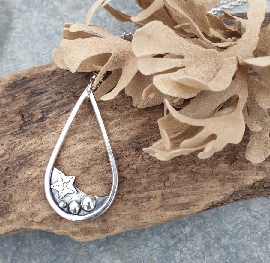 Silver teardrop rockpool beach pendant with starfish