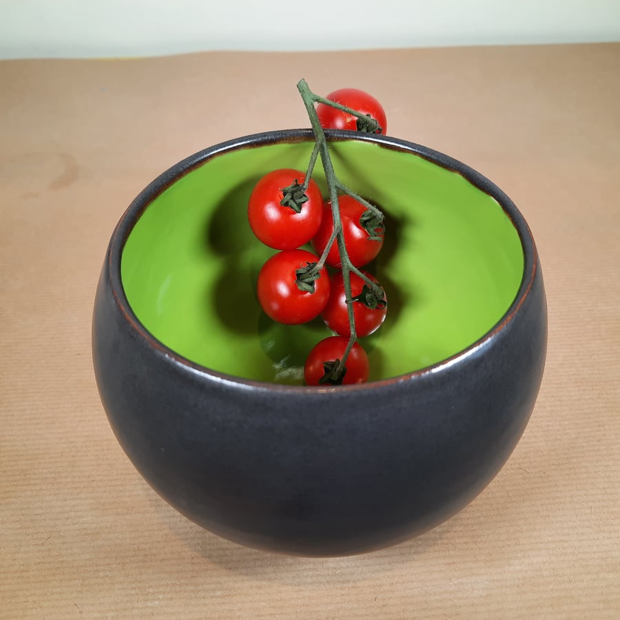 Small hand made rounded green and black ceramic bowl