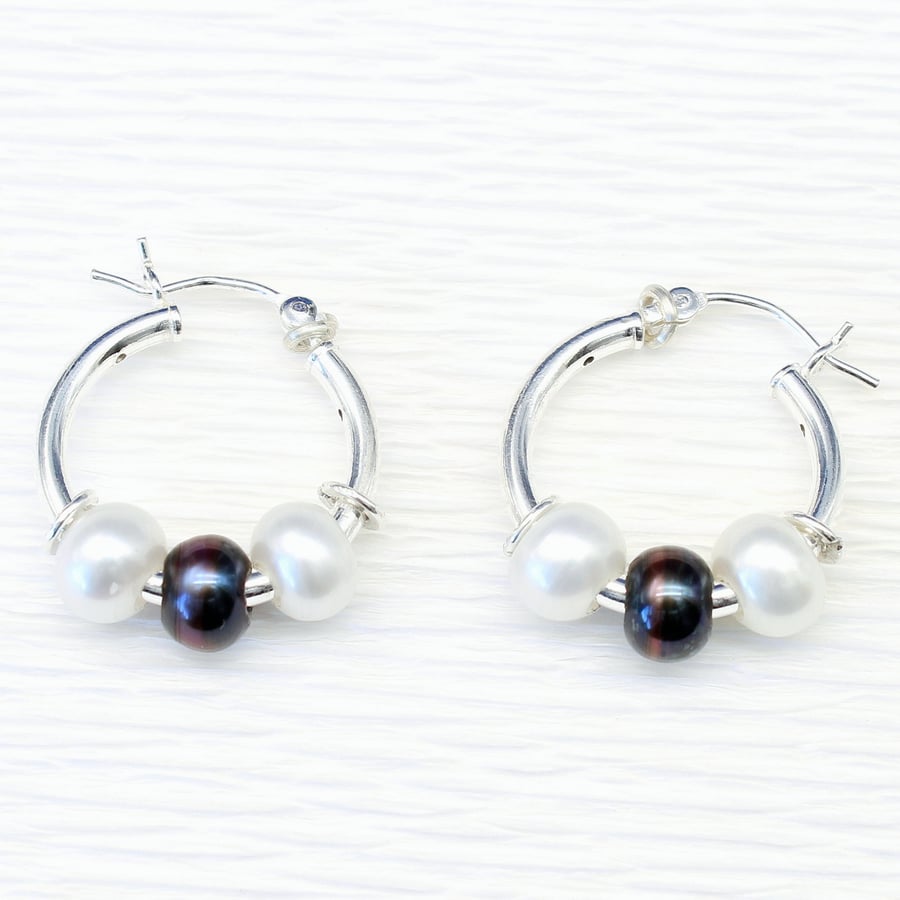 Handmade freshwater pearl earrings featuring white and peacock pearls. 