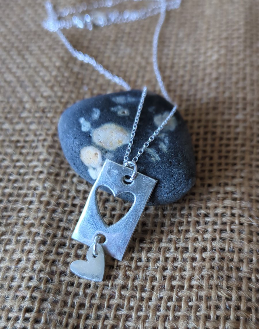 Silver pendant with heart cut out design