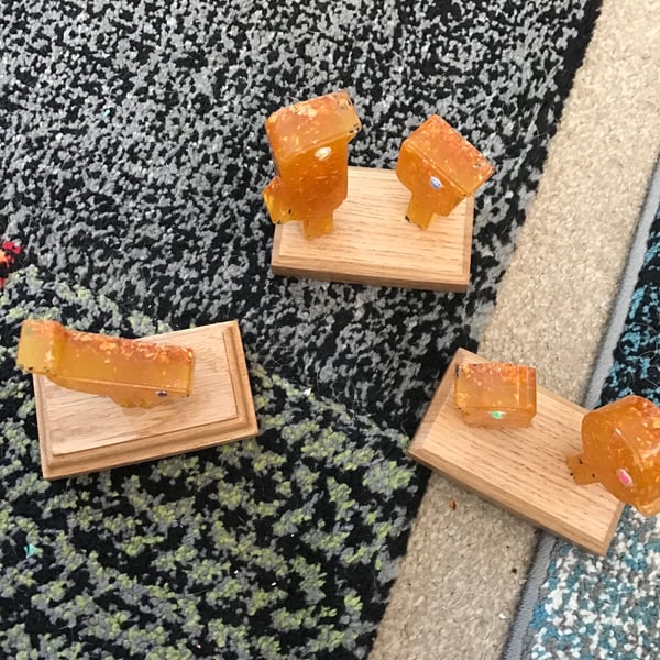 Set of three quirky orange birds on bases in resin