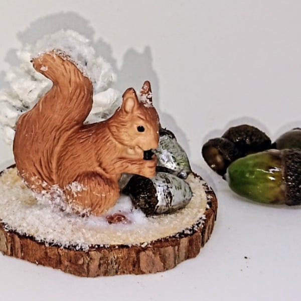 Squirrel on a log slice in snow scene autumn Christmas decoration 