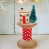 Little wooden Christmas house on a vintage bobbin