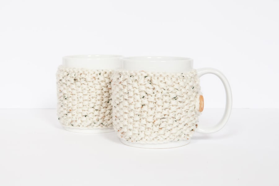 Pair of knitted mug cosies, cup cosy, coffee cosy in oatmeal. Coffee mug cosy