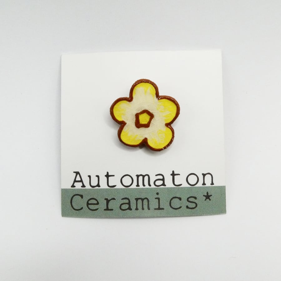 Yellow flower ceramic pin badge.