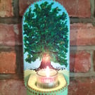 A wall mounted candle holder for a tealight