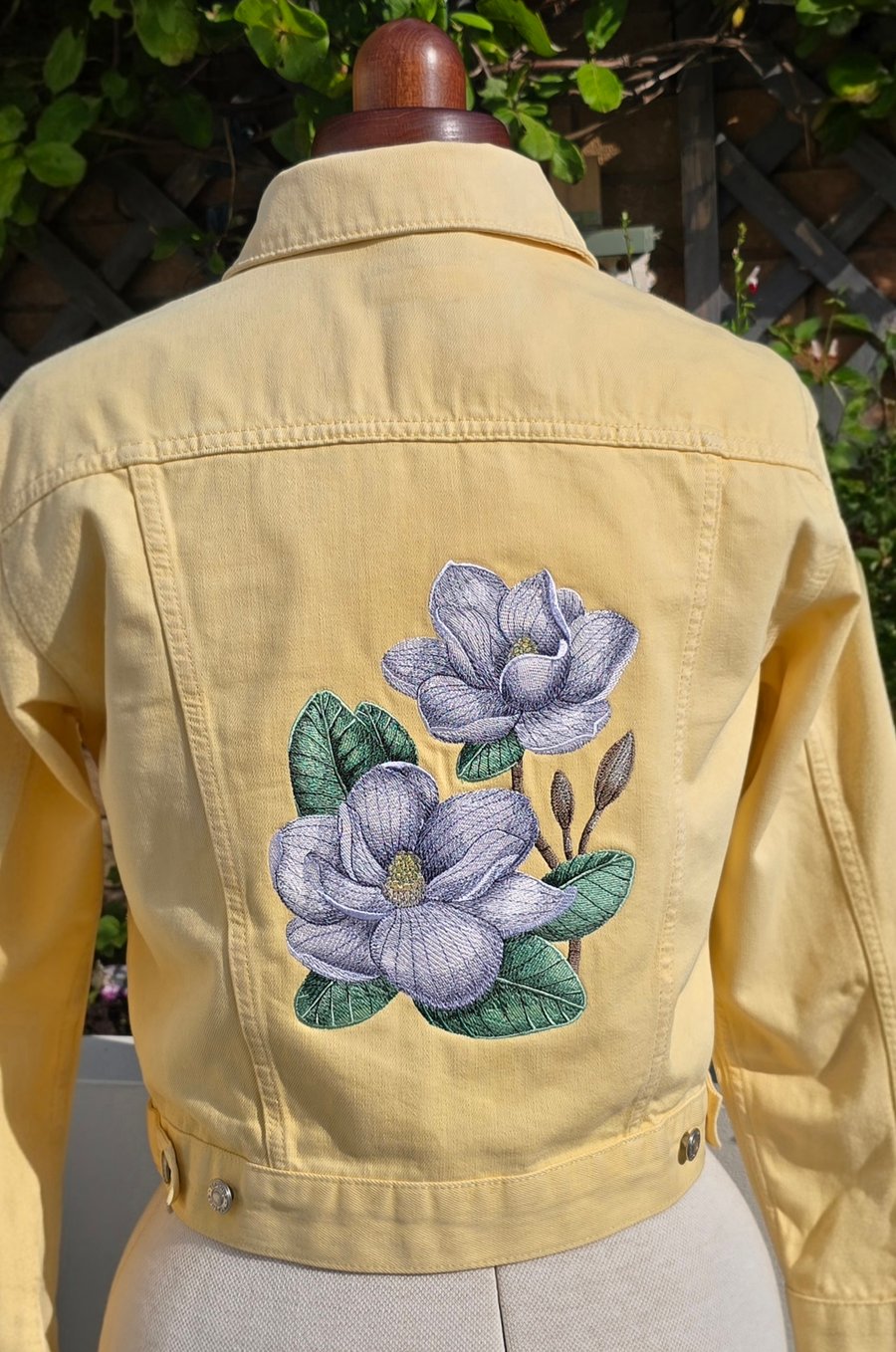Machine embroidered soft yellow denim jacket with large magnolia design