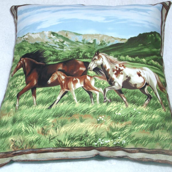 Two horses and a foal trotting across a valley cushion 