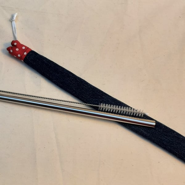Reusable metal straw and cleaning brush with denim cover.