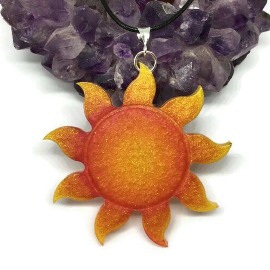 Glitter Sun large statement pendant with a black cord chain.