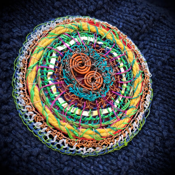 Flat disc brooch in yellow, copper, green made from recycled materials