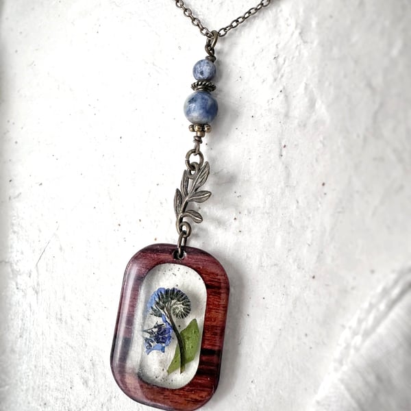 Forget Me Not Wood and Resin Pendant with an  Antique Brass Plated Chain.