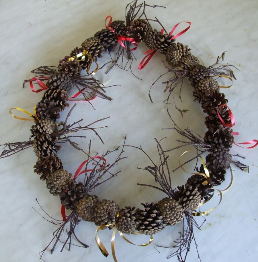 Christmas wreath with natural twigs & fir cones decorated with curling ribbon.