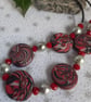 Disc shaped necklace in a red, black and silver swirl design - Image 2