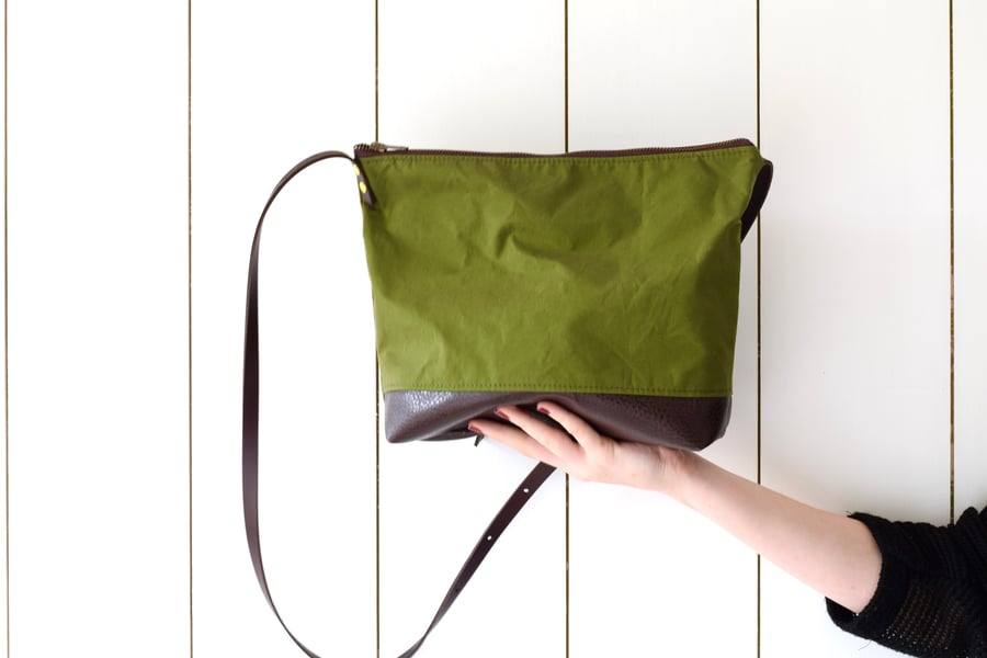 Green canvas cross body bag with leather base and leather adjustable straps