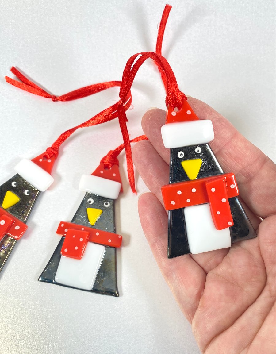Cute fused glass penguin with a Christmas decoration 