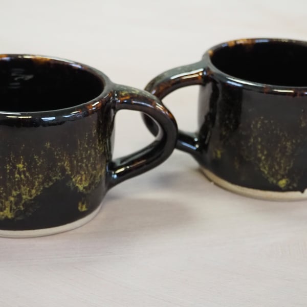 Pottery mug finished in a glossy black,yellow,green combo glaze