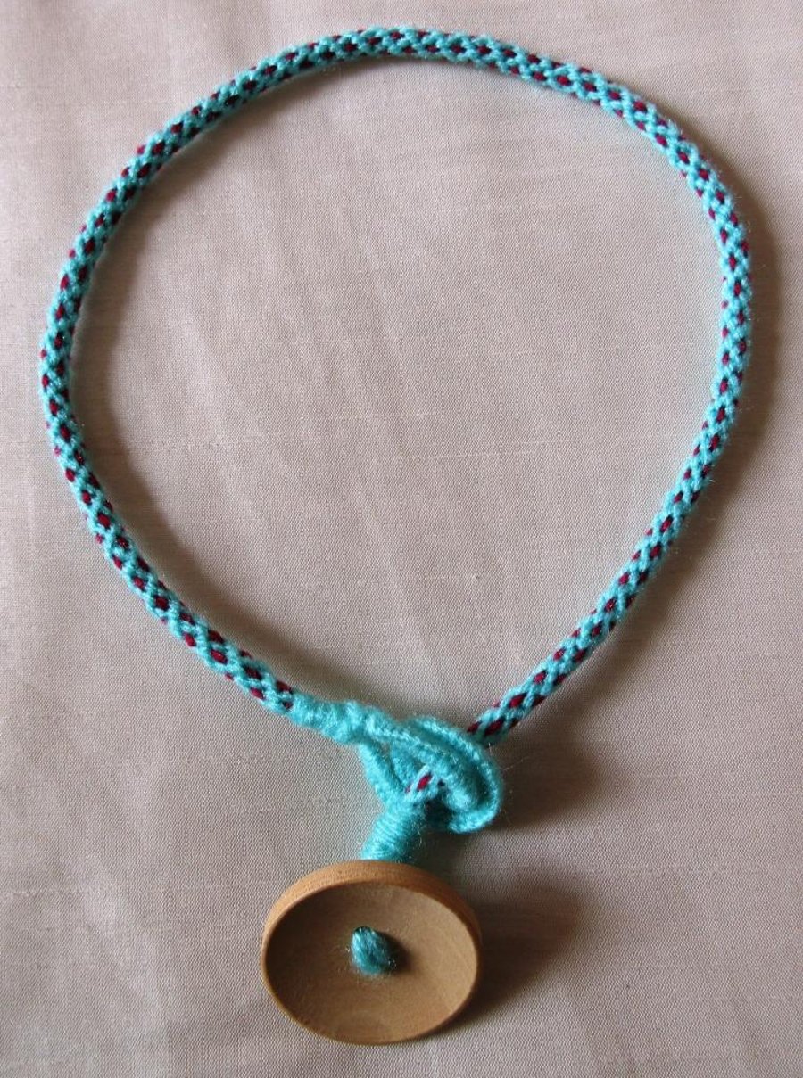 A necklace in kumihimo braid with button trim