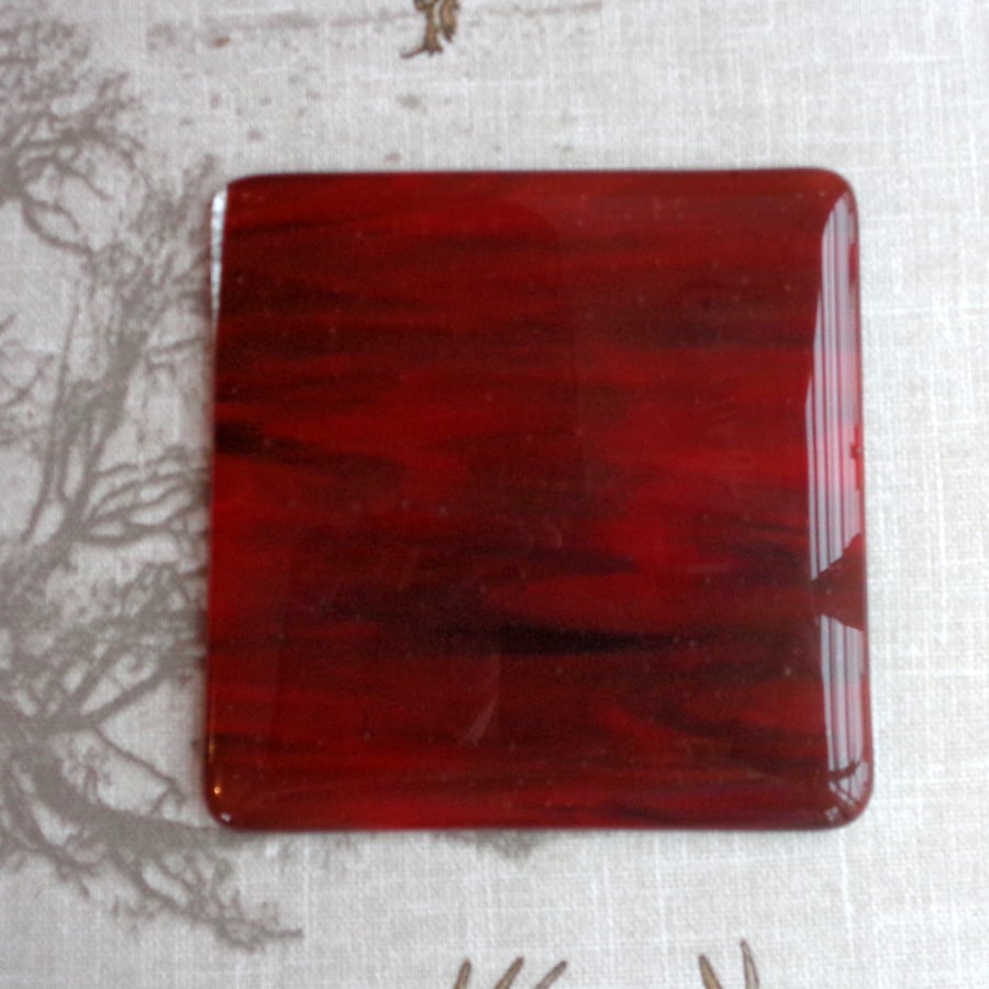 Fused glass coaster in shades of deep streaky red 