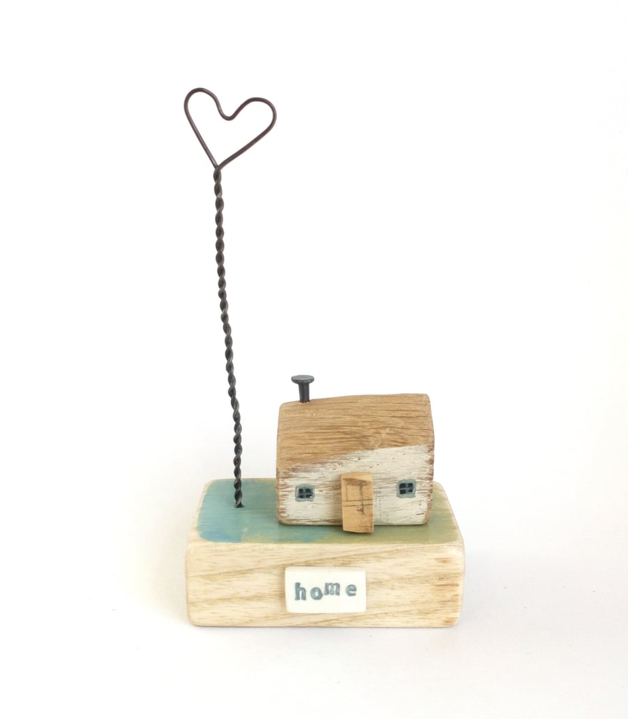 Little wooden house with a wire love heart