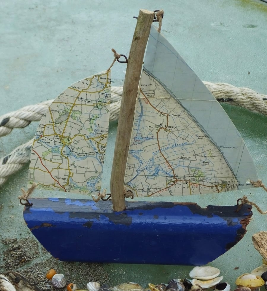 Blue hull driftwood sailing ship yacht with ordnance survey map sails