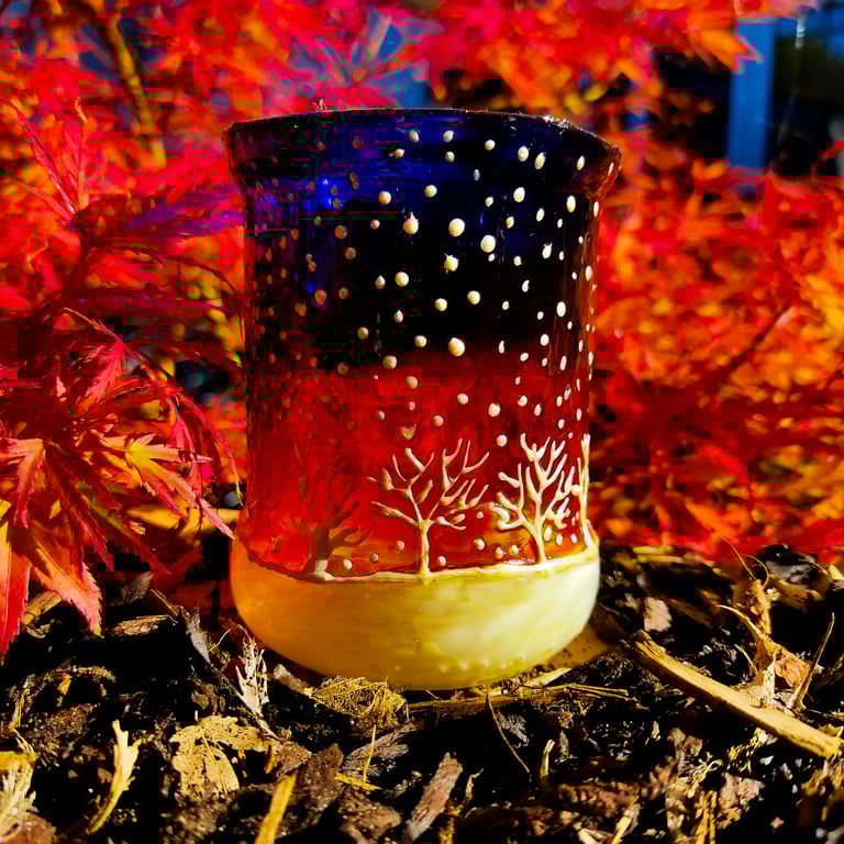 Glass painted handmade candle holder with late sunset and row of frosty trees