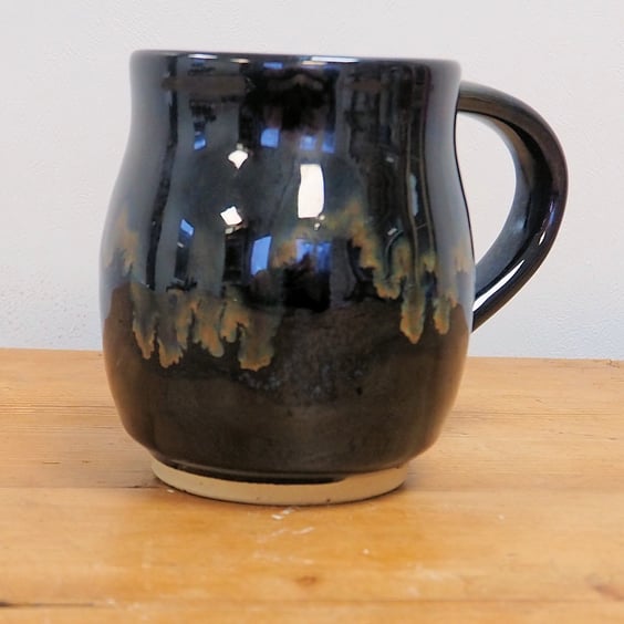 Large pottery mug finished in a black glaze with gold blue tones, handmade