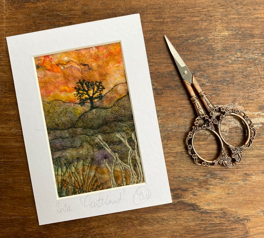 Embroidered wet felting sunset moorland landscape with tree. 