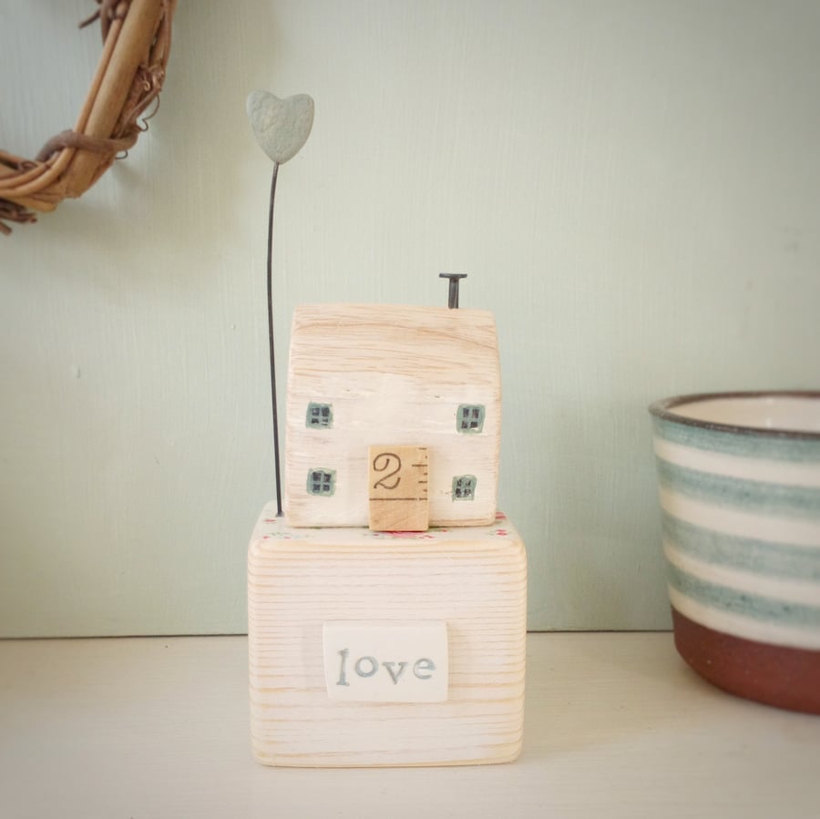 Wooden house with clay heart 'love'