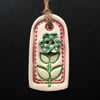 Small pink ceramic tag decoration with flower button