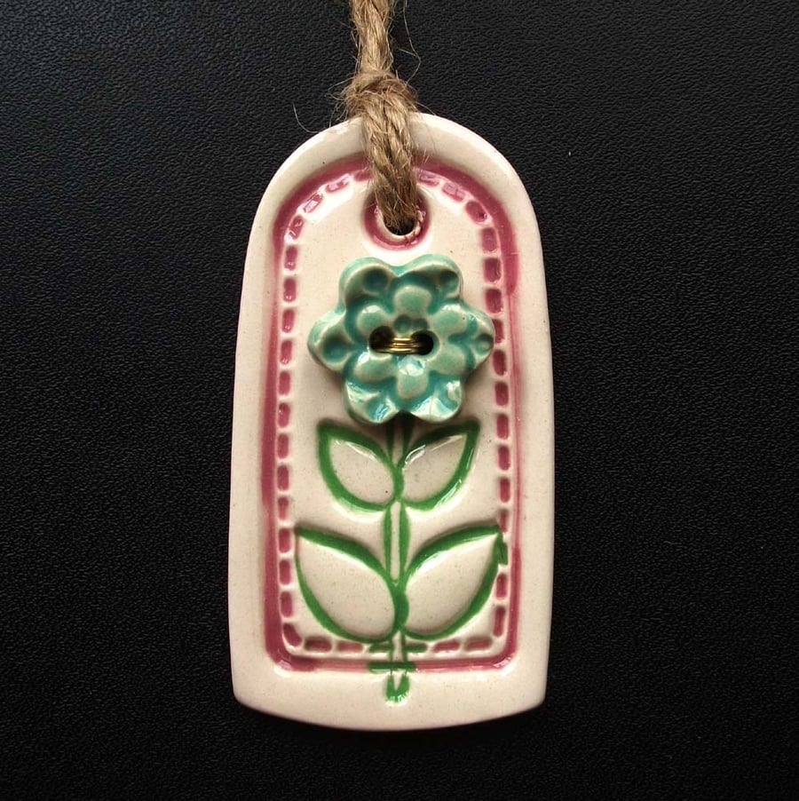 Small pink ceramic tag decoration with flower button