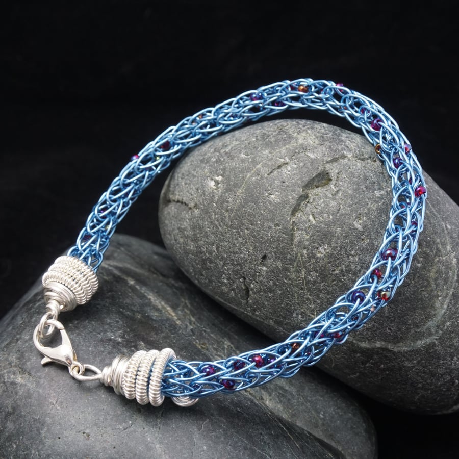 Blue viking knit bracelet with purple & red beads