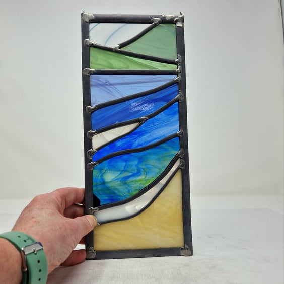 Stained glass beach study seascape in strong colours, leaded hanging panel.