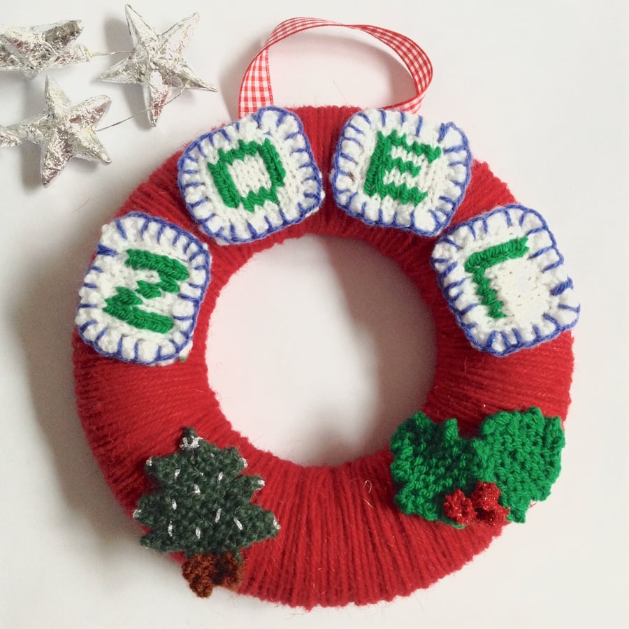 Red wool Christmas wreath with knitted decorations