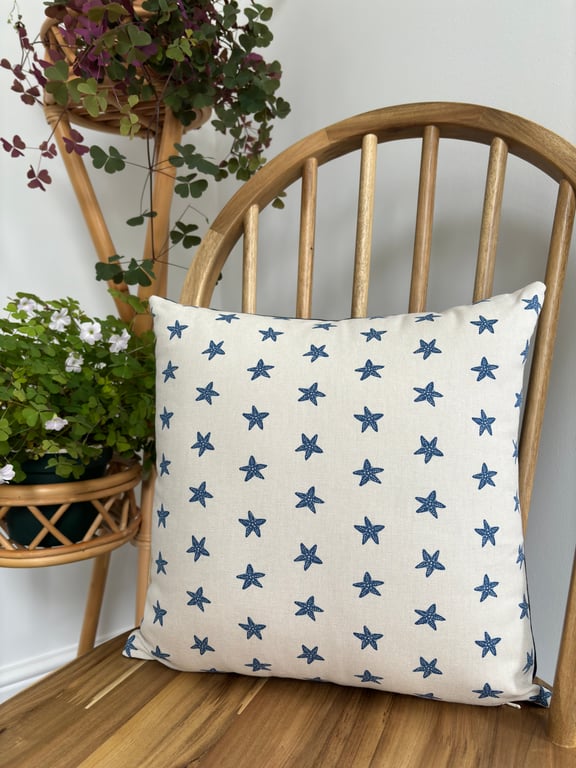 Cushion cover in taupe with navy starfish print, 36cm x 36cm. 