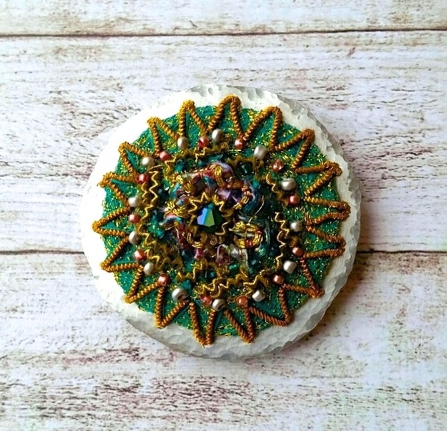 Ornate embroidered brooch.