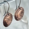 Copper disc earrings with abstract design