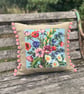 Bright floral tapestry cushion cover with reclaimed linen and pink pompoms