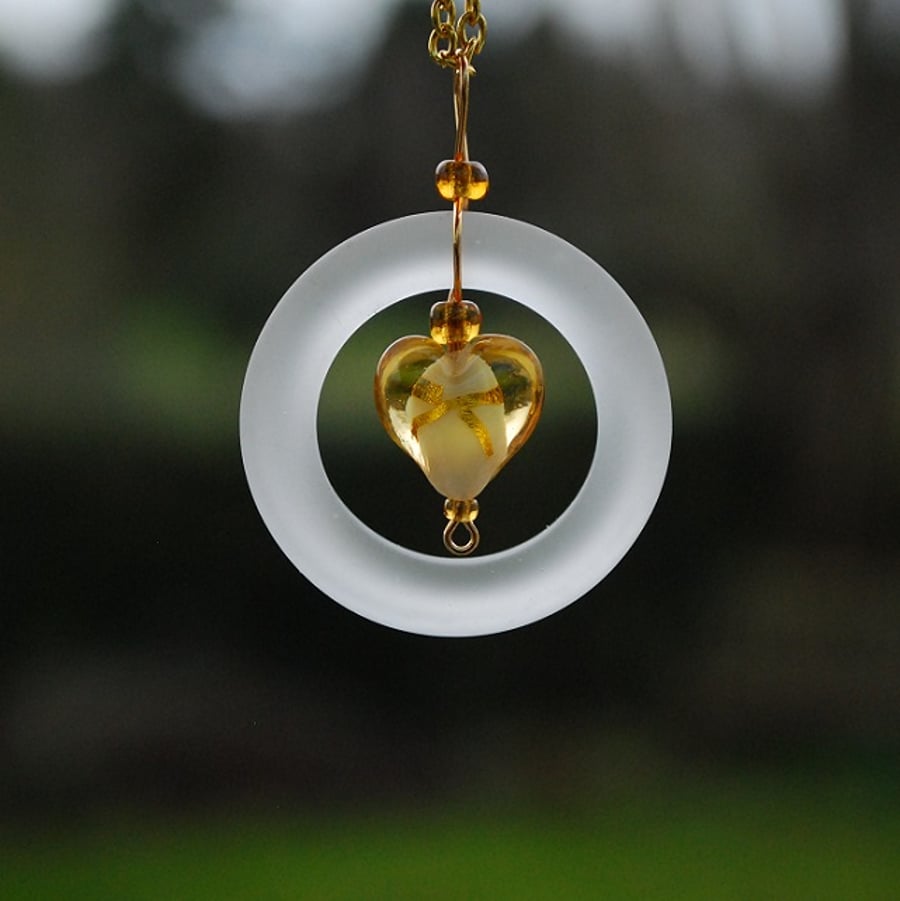 White glass ring pendant with gold heart