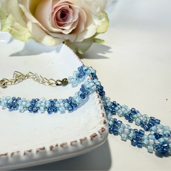 Blue daisy chain bracelet with lobster clasp.