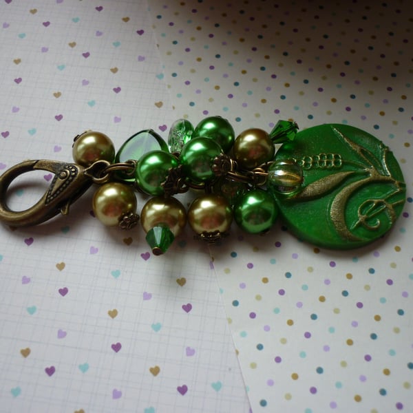 GREEN AND ANTIQUE BRONZE BAG CHARM.  