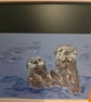 Otters frolicking on A5 paper 