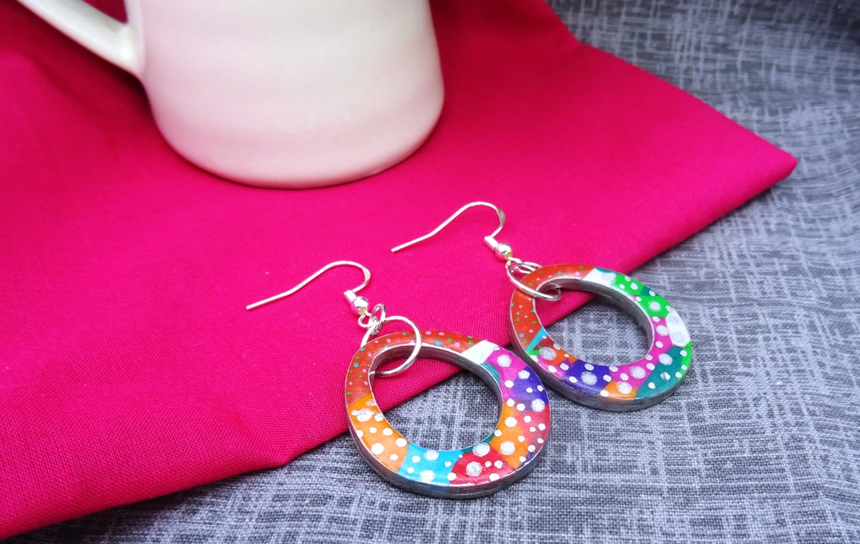 Multicoloured dangly polymer clay earrings with dots.