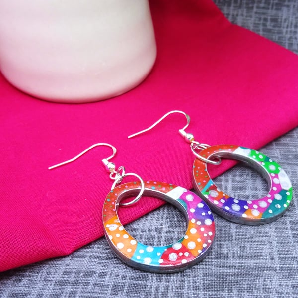 Multicoloured dangly polymer clay earrings with dots.