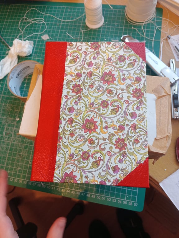 Red leather and decorative paper notebook about A6 size. Slim and portable